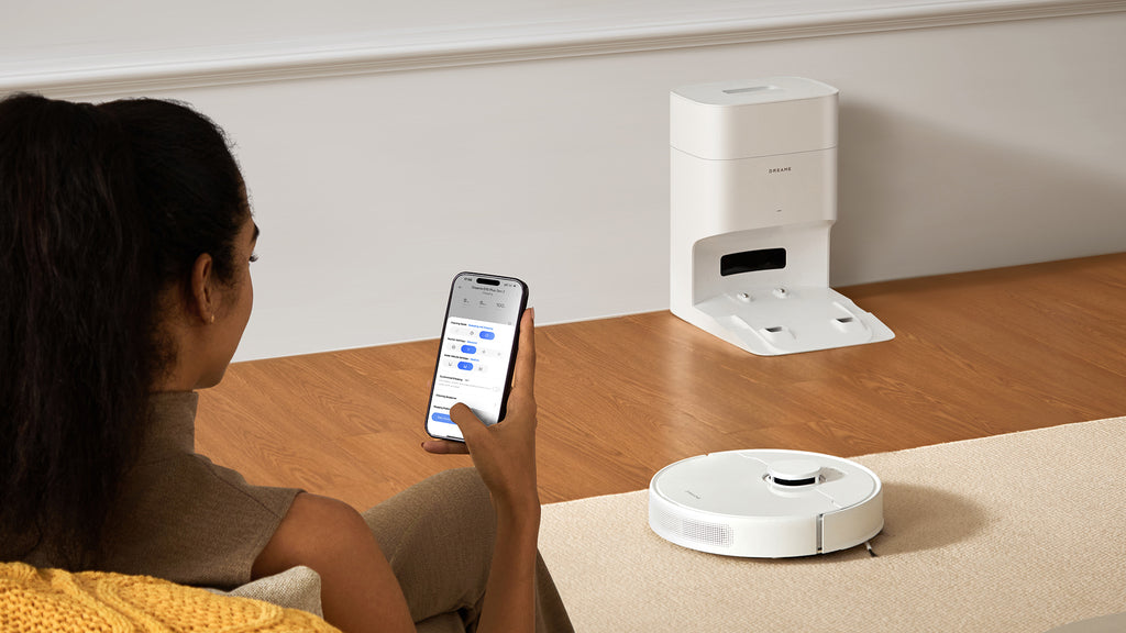 A woman controlling a robot vacuum on the app.