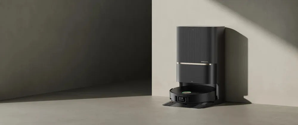 Dreame robot vacuum parked in its self-emptying dock, tucked into a corner against the wall.