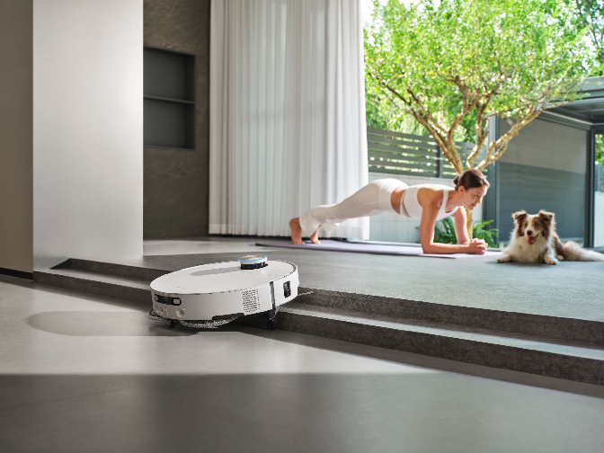 Dreame robot vacuum crossing a door threshold on retractable legs.