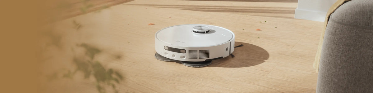 Dreame robot vacuum for hardwood floors gliding over wooden surface, cleaning dust and debris with floor-safe brushes.