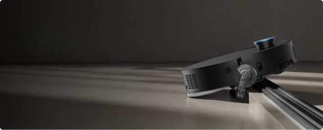 Dreame X60 Max Ultra Complete robot vacuum climbing a raised threshold.